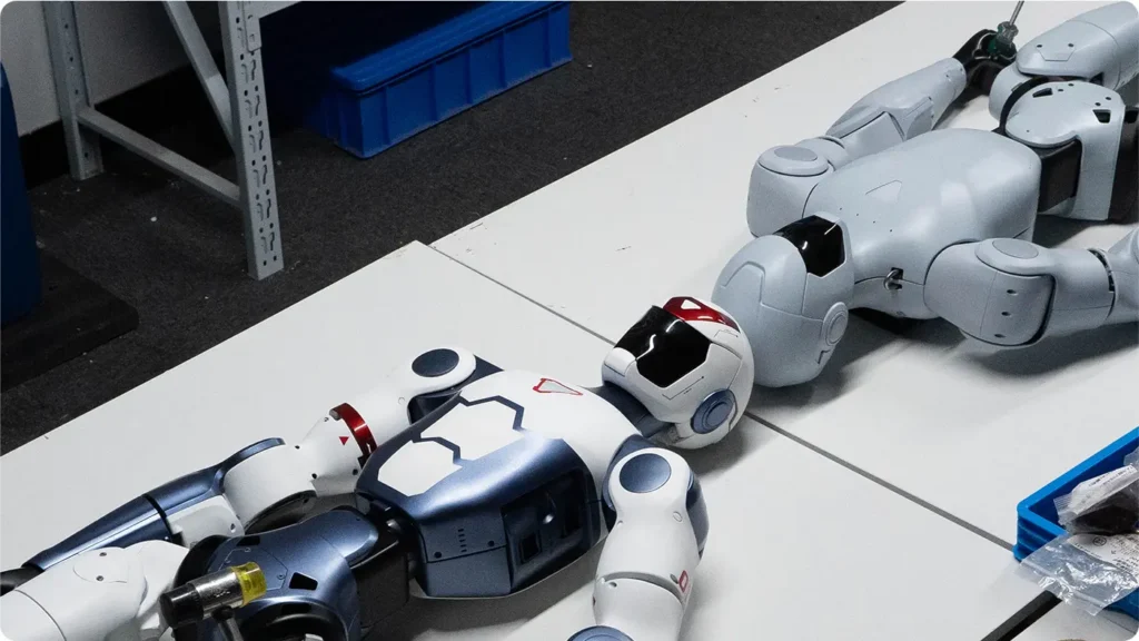 Robot humanoïde Unitree R1 posé sur un établi pour maintenance