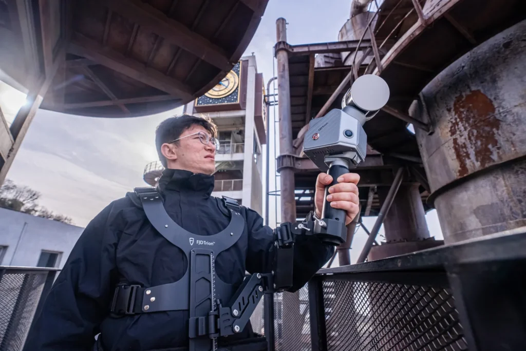 Opérateur équipé du gilet stabilisateur portant le scanner FJD Trion S2 sur site industriel